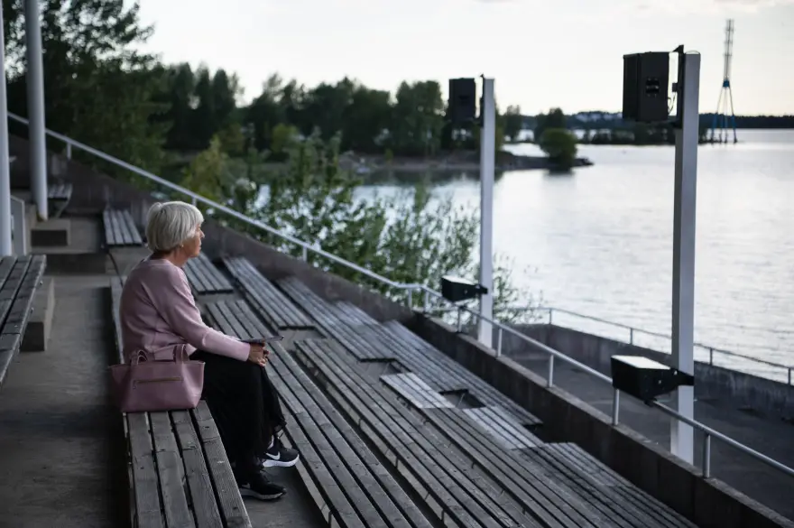 Kuva Jana Windererin teoksesta vuodelta 2020. Yleisön jäsen, harmaahiuksinen nainen katselee merelle puisista penkeistä muodostuvasta katsomosta.