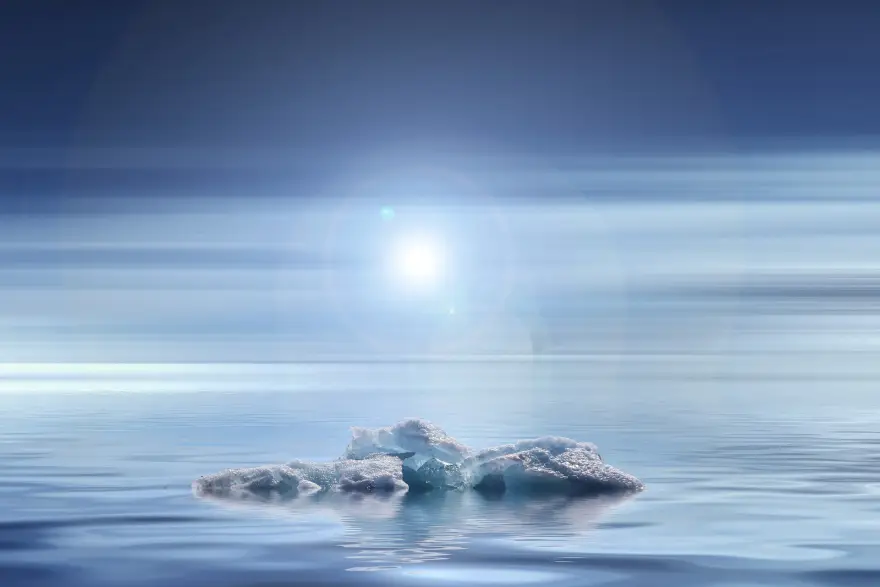 An ice fragment floats in the sea, merging into the sky.