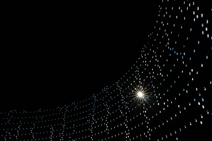Light art installation Oil Tank 468, small points of light are visible through the wall on the right side of the image, with the rest in darkness.